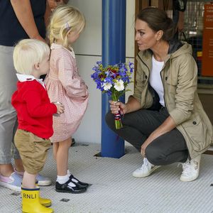 Prinzessin Kate nimmt kniend Blumen von Kindern entgegen