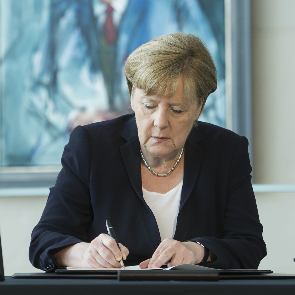 Angela Merkel mit einem Bild von Helmut Kohl
