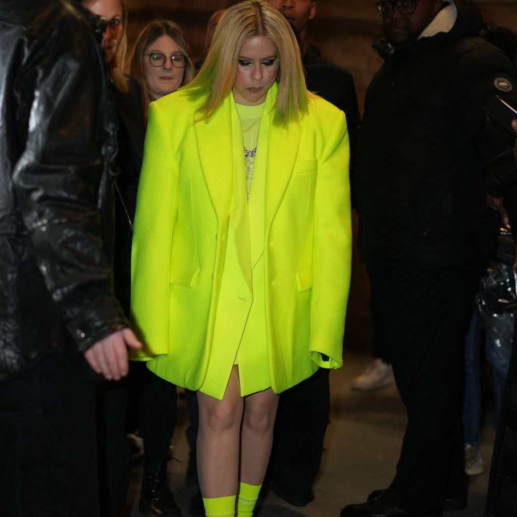 Sängerin Avril Lavigne in neongelbem Outfit bei einer Fashion Show in Paris