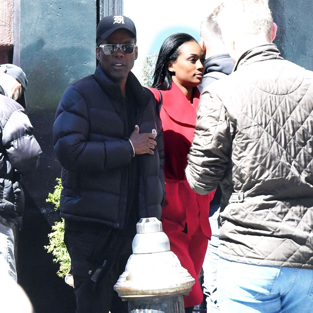 Chris Rock mit einer Frau im roten Mantel