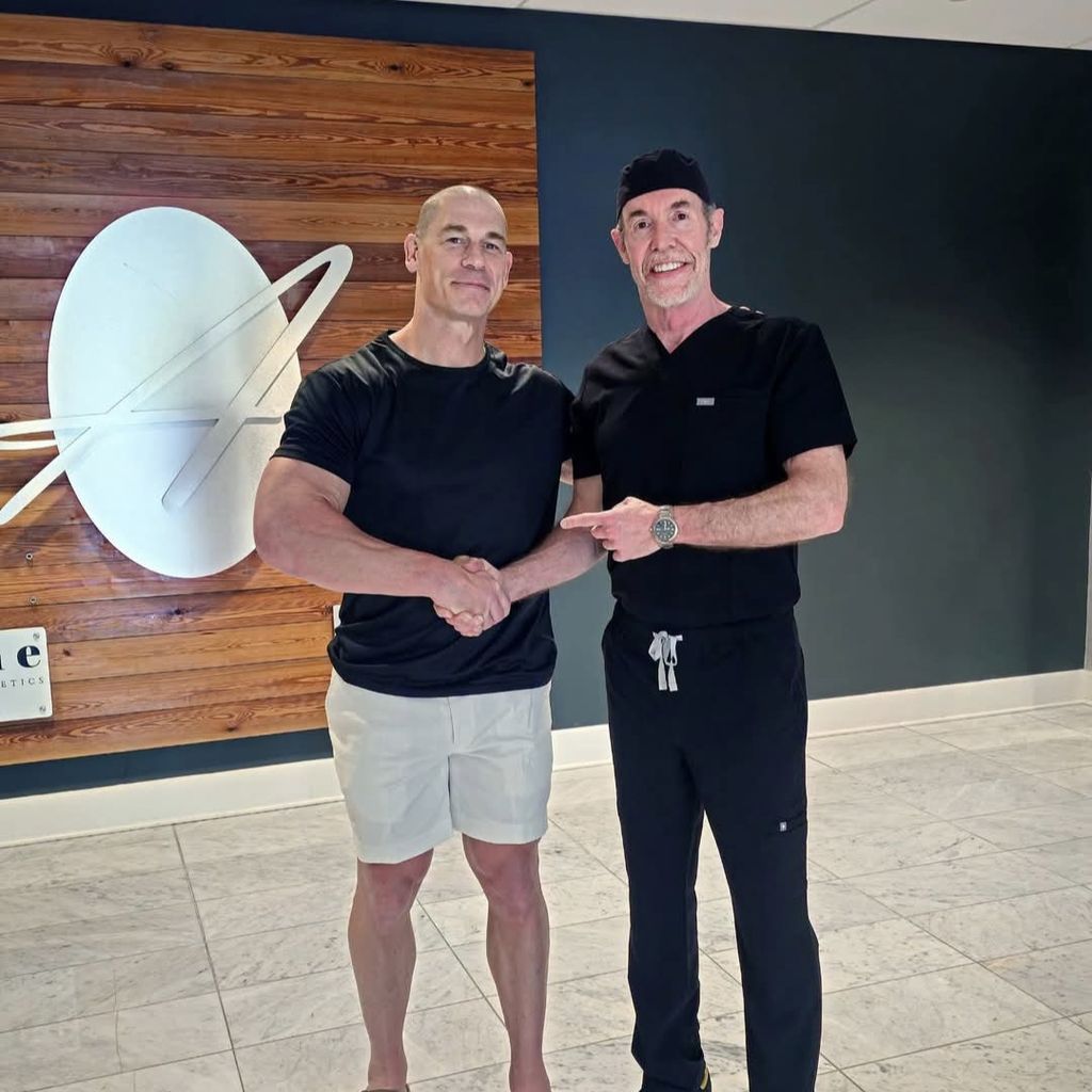Der ehemalige Wrestler John Cena teilte ein Foto von sich mit glattem Kopf, auf dem er dem Haarchirurgen Dr. Ken Anderson die Hand schüttelt.