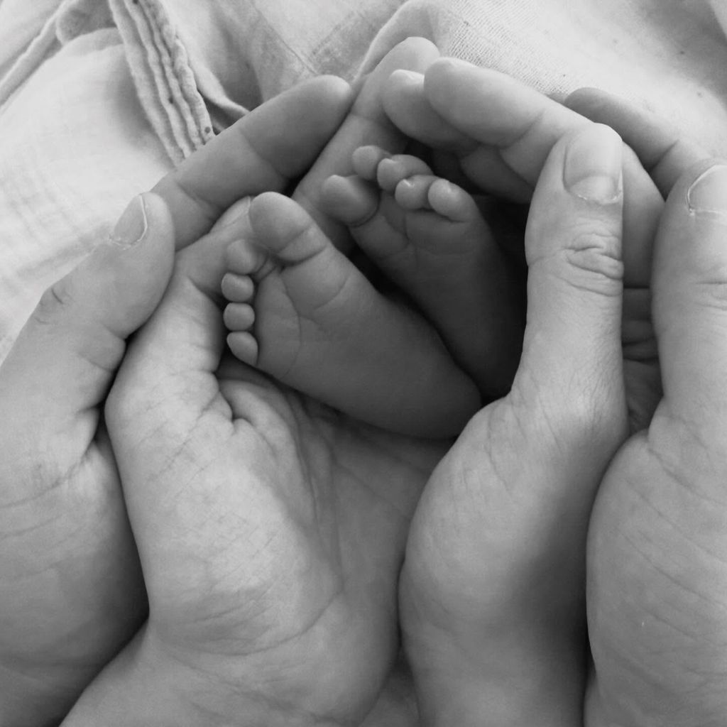 Die Hände von Mesut Özil und seiner Frau umschließen die Füße ihrer Tochter