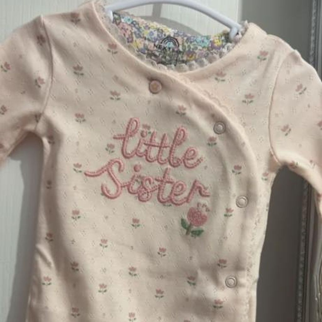 Ein rosafarbener Babystrampler von Lucy Fallons Baby-Ankündigung
