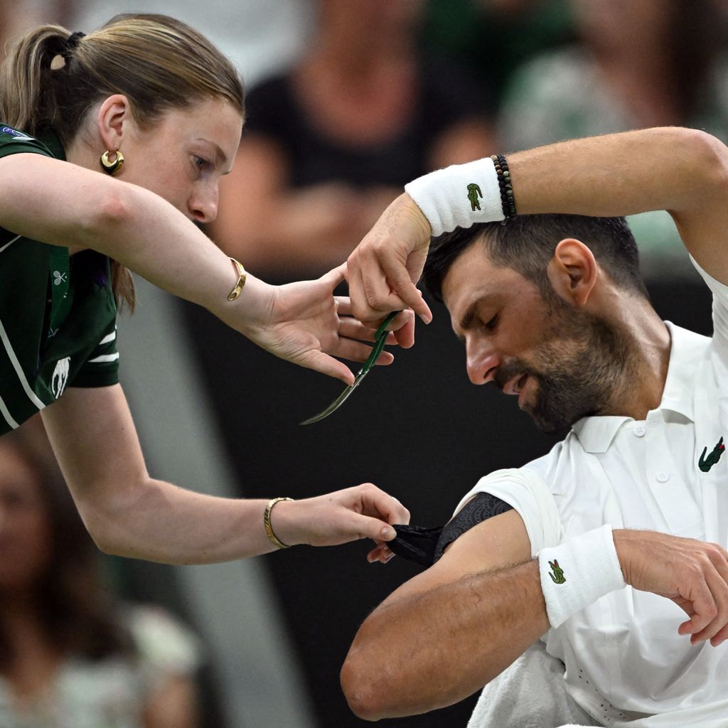 Novak Djokovic lässt sich während des Matches von einem Ballmädchen das Tape schneiden