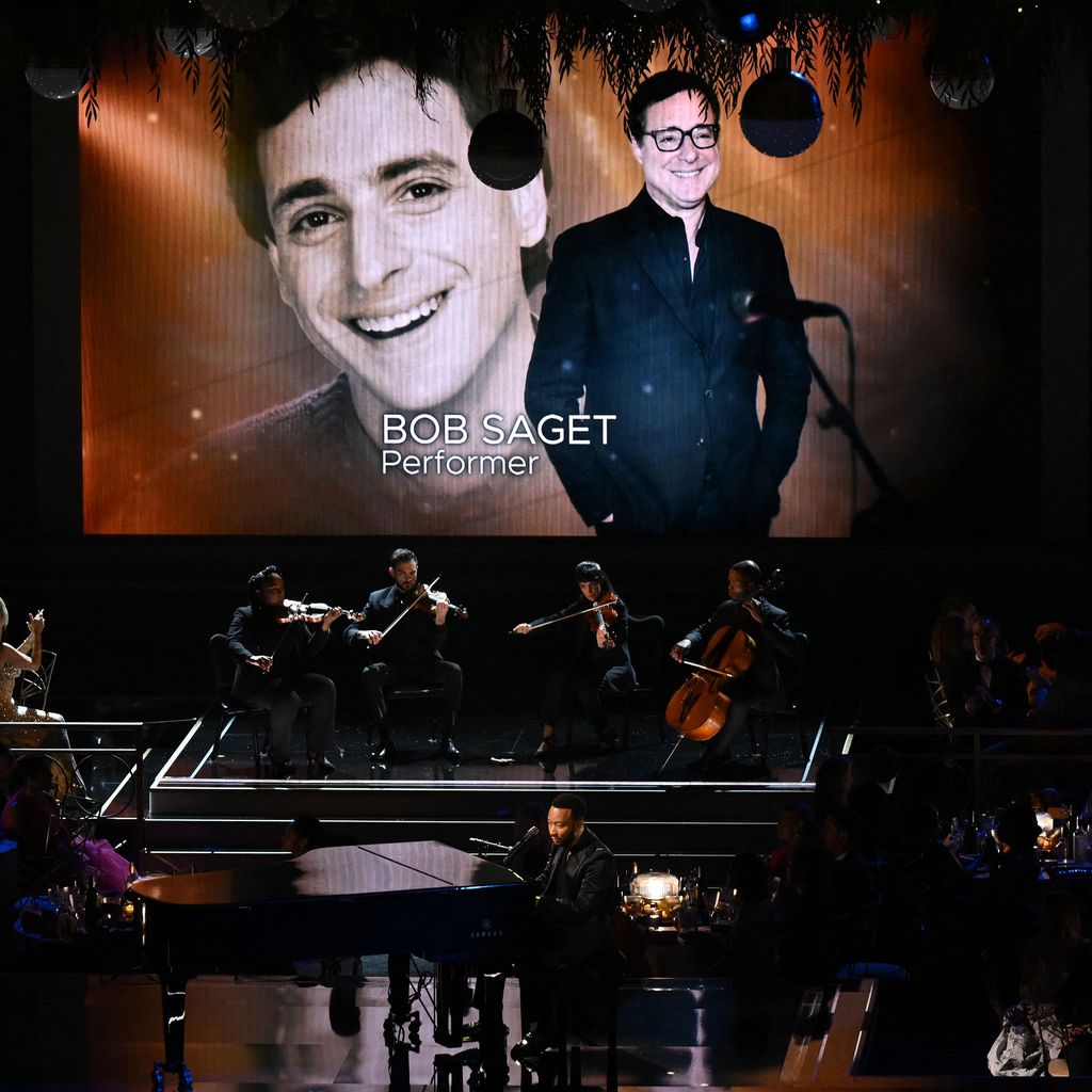 John Legend auf der Bühne, während im Hintergrund Bob Saget erinnert wird