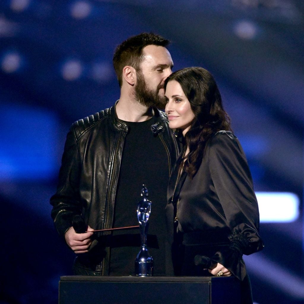 Johnny McDaid und Courteney Cox auf der Bühne bei den Brit Awards 2022 in London