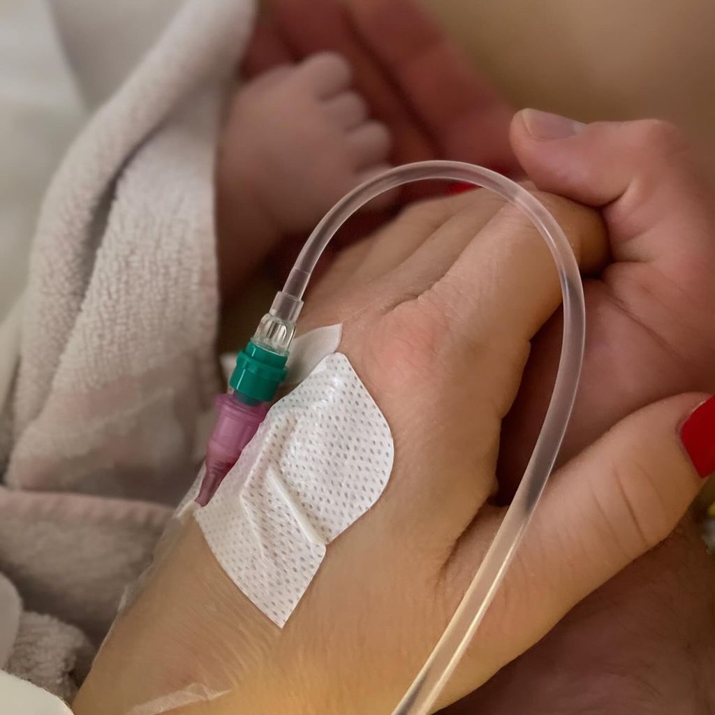 Katharina Wagener und Kevin Yanik halten Händchen mit ihrem Baby