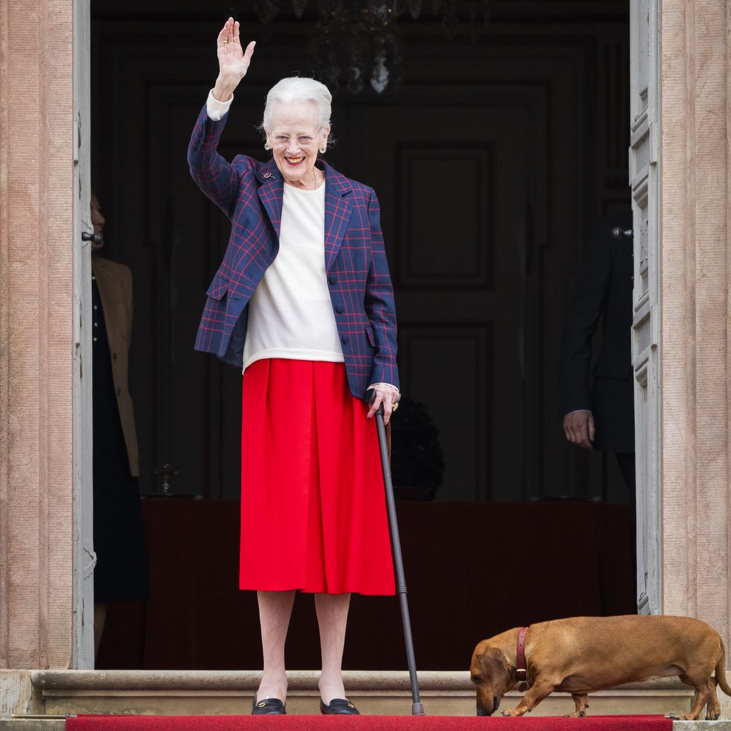 Königin Margrethe II. winkt auf den Stufen von Schloss Fredensborg, neben ihr Dackel Tilia, anlässlich ihres 86. Geburtstags