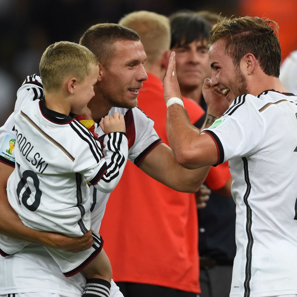 Lukas Podolski mit seinem Sohn auf dem Arm und Mario Götze, 2014