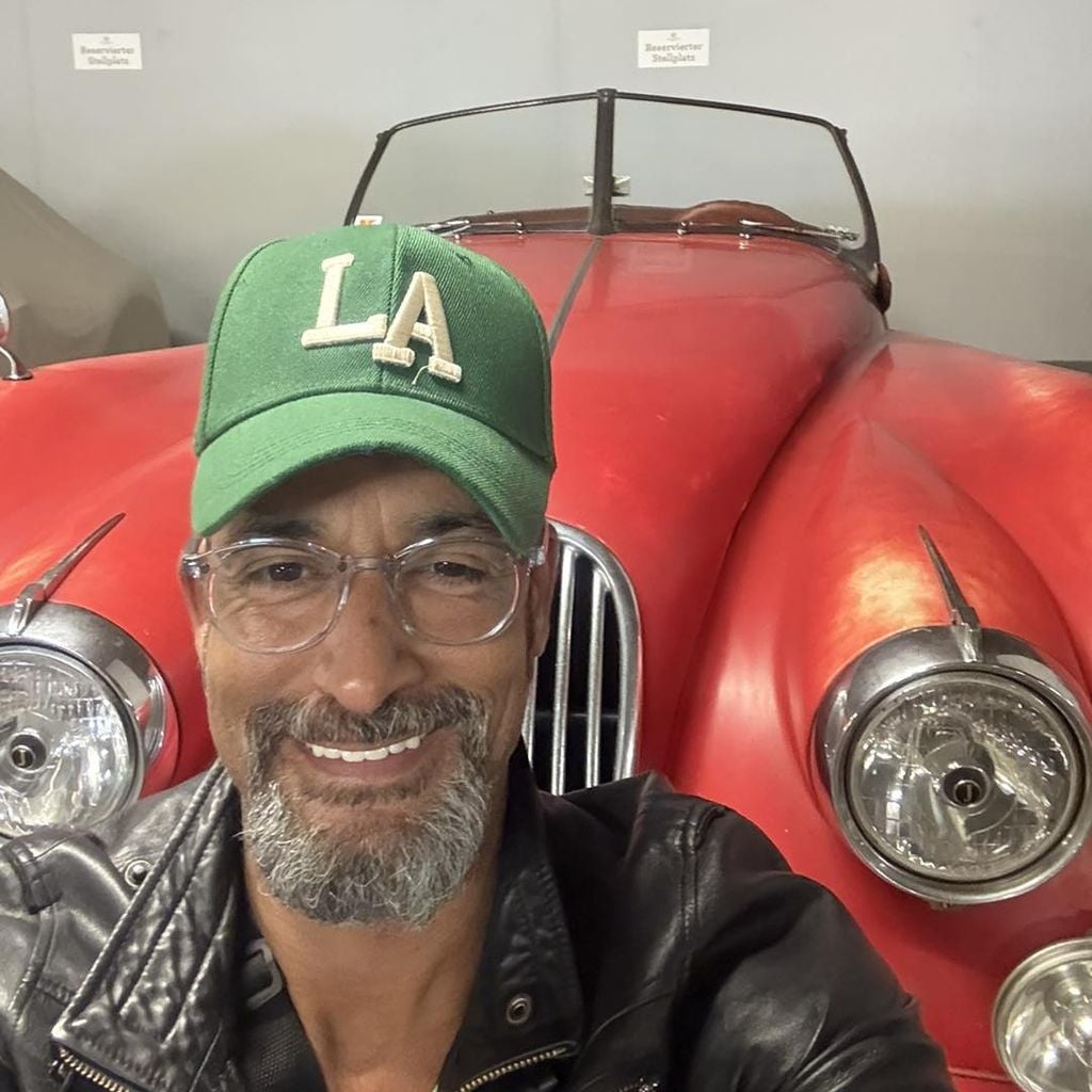 Mark Medlock posiert im April 2026 vor einem Oldtimer