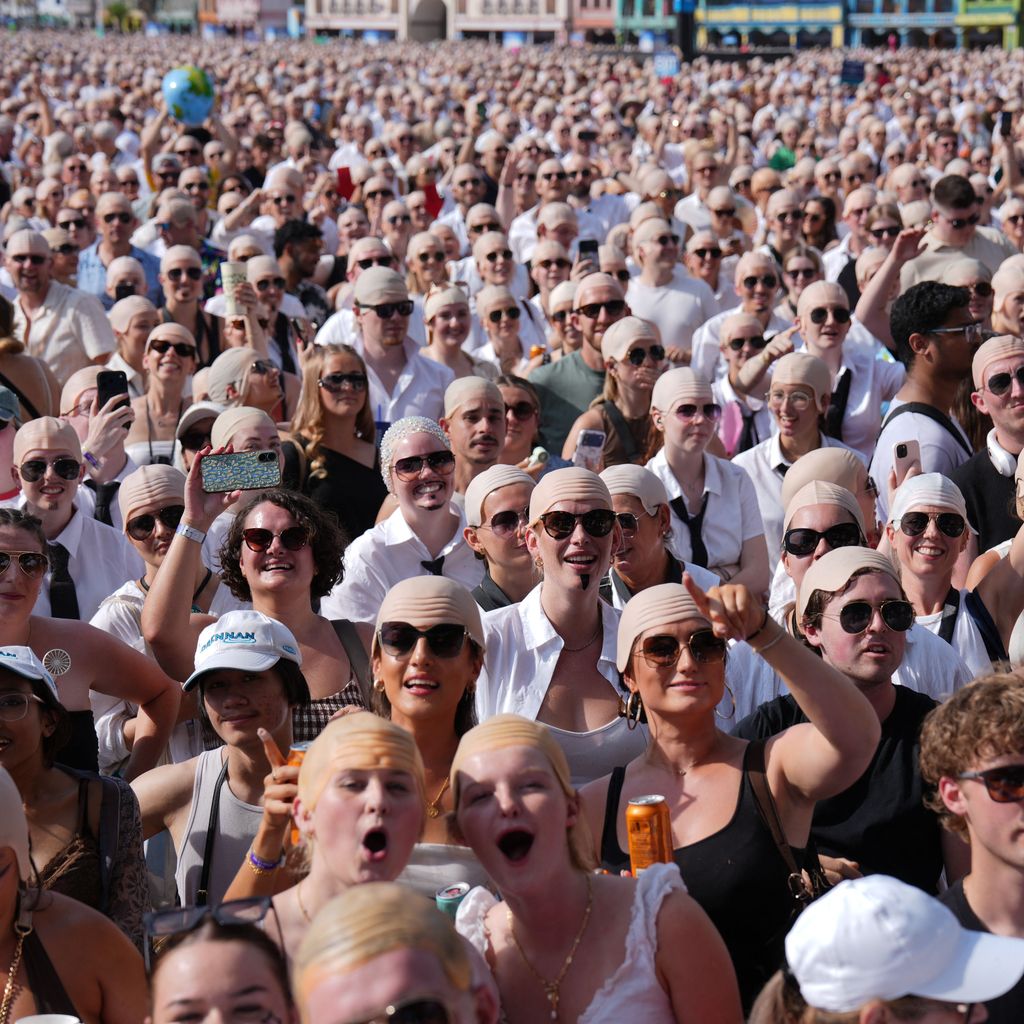 Fans mit Glatzenkappen vor Pitbulls Konzert im Hyde Park in London, 10. Juli 2026, mit Guinness-Weltrekordversuch