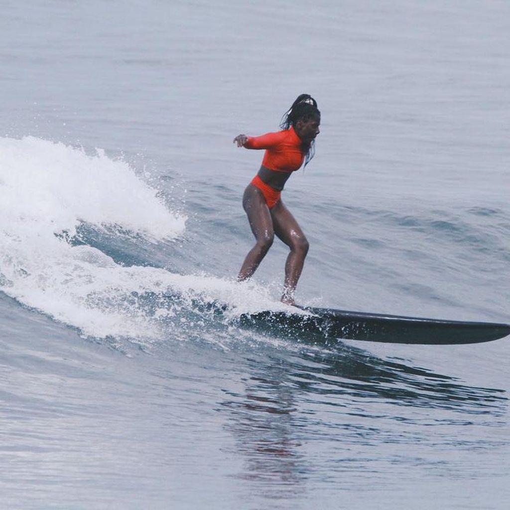 Nikeata Thompson auf einem Surfboard