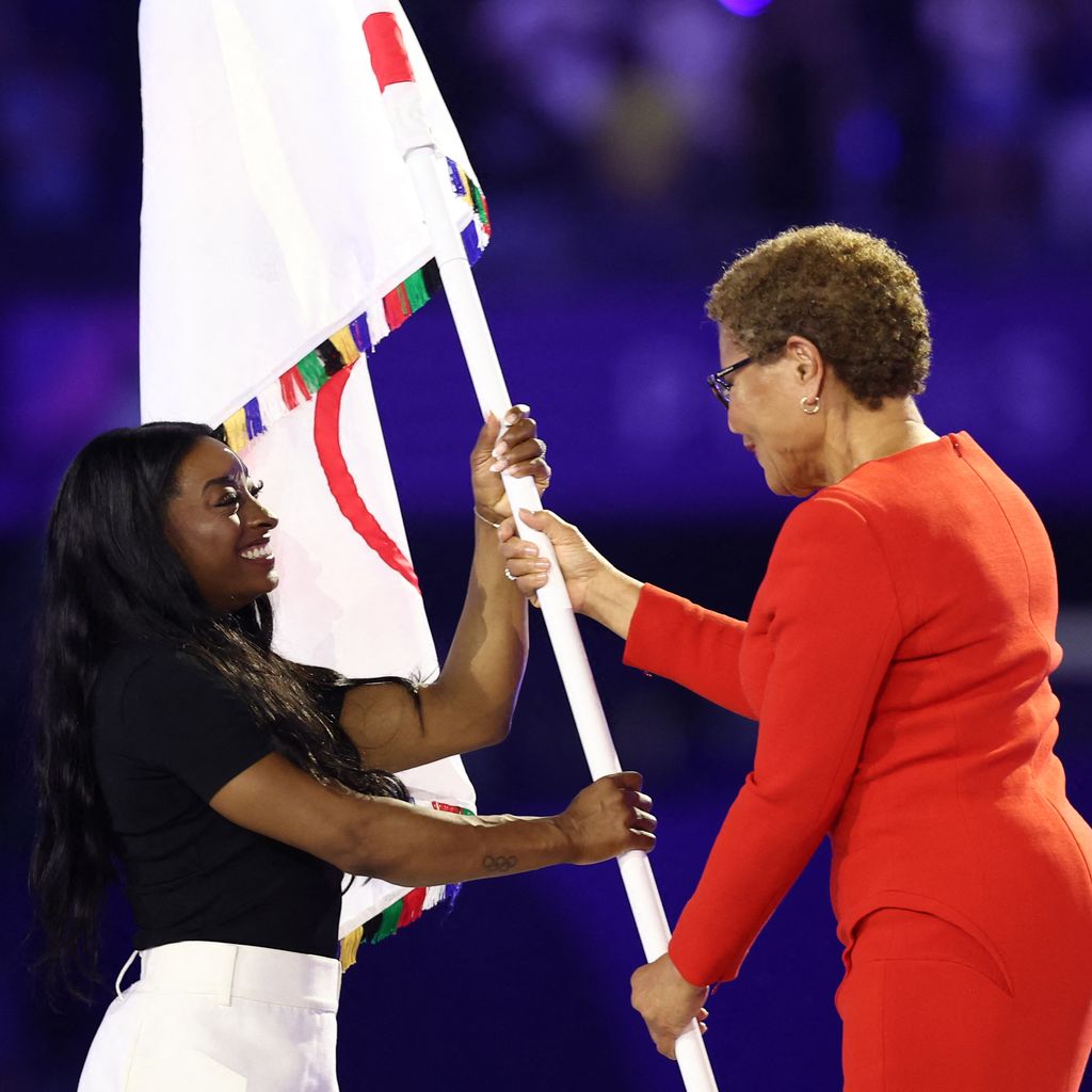Simone Biles mit der Bürgermeisterin von L.A. bei der olympischen Flaggenübergabe