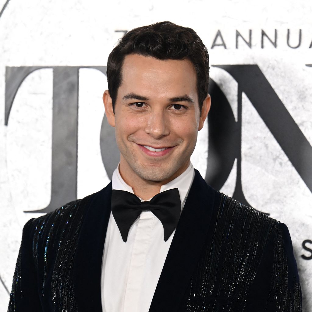 Skylar Astin lächelnd im Anzug, 2022