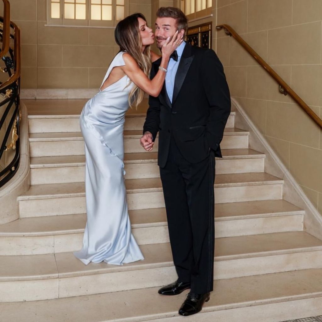 Victoria Beckham küsst ihren Ehemann David Beckham auf die Wange