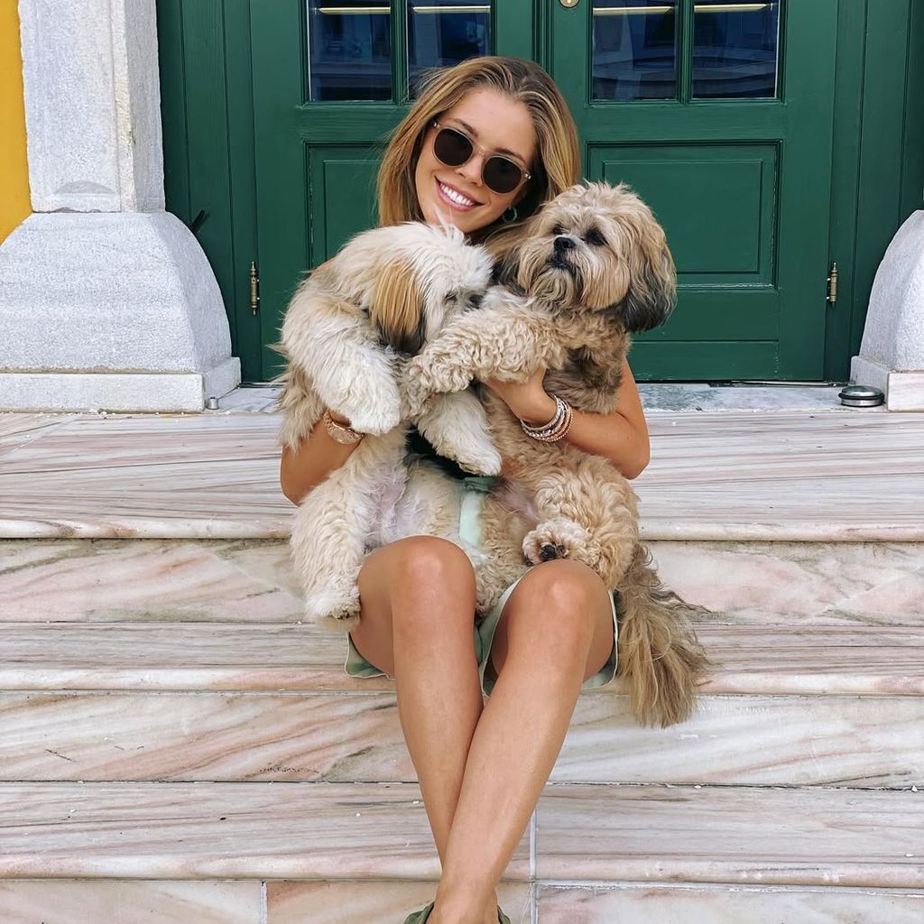 Victoria Swarovski kuschelt mit zwei Hunden.