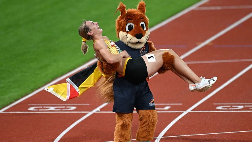 Alexandra Burghardt feiert mit Maskottchen Gfreidi nach EM-Gold in der 4x100-m-Staffel in München 2022.