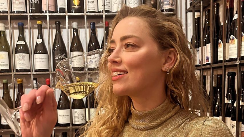38 Jahre alt! Amber Heard feiert mit einem Glas Champagner