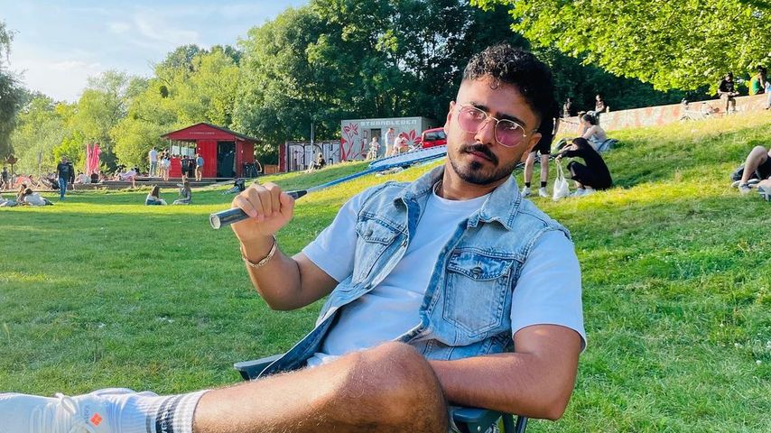 Amir Hosseiny sitzt im Freien