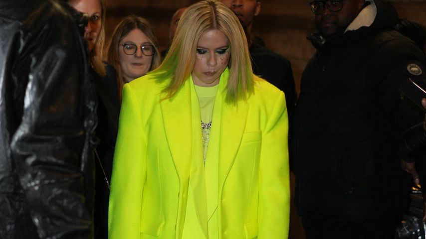 Sängerin Avril Lavigne in neongelbem Outfit bei einer Fashion Show in Paris