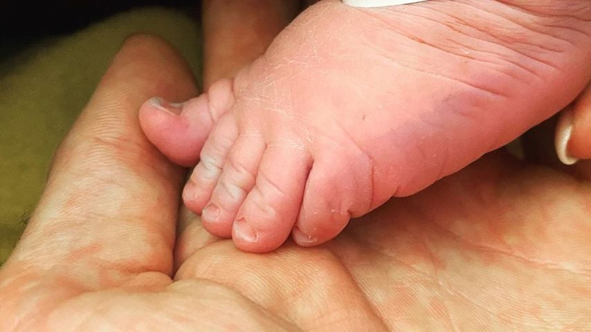 Chris Broys Hand mit dem Fuß seines Sohnes George Angelos