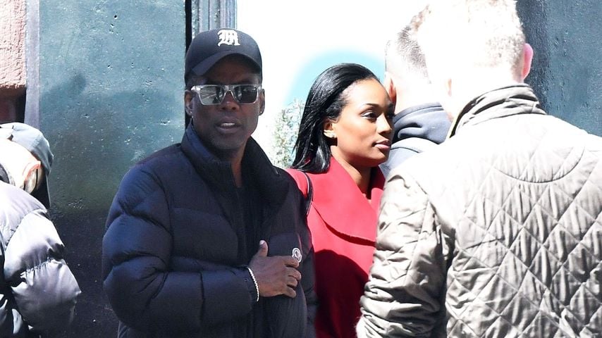 Chris Rock mit einer Frau im roten Mantel