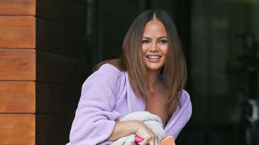 Bequem: Chrissy Teigen flaniert im Bademantel und mit Decke