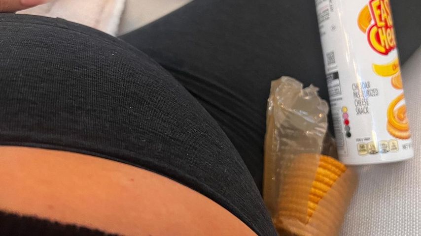 Chrissy Teigen mit Keksen und Sprühkäse im Bett