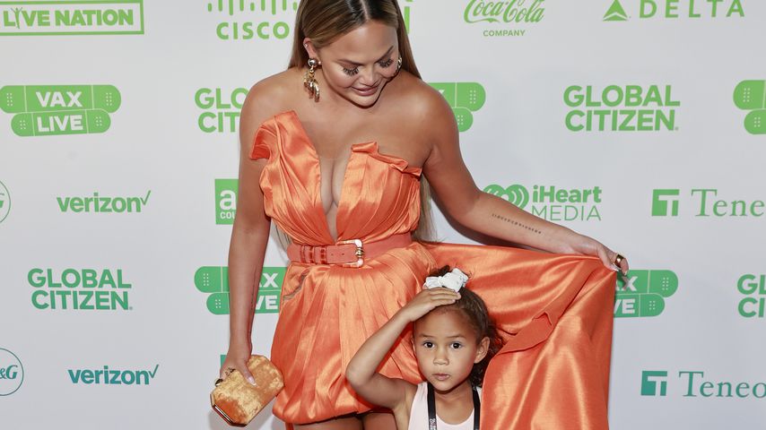 Unterm Kleid versteckt: Chrissy Teigen mit Luna auf Event