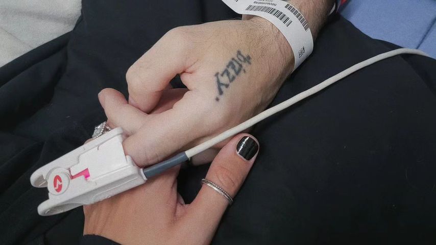 Deryck Whibleys Frau Ari hält seine Hand