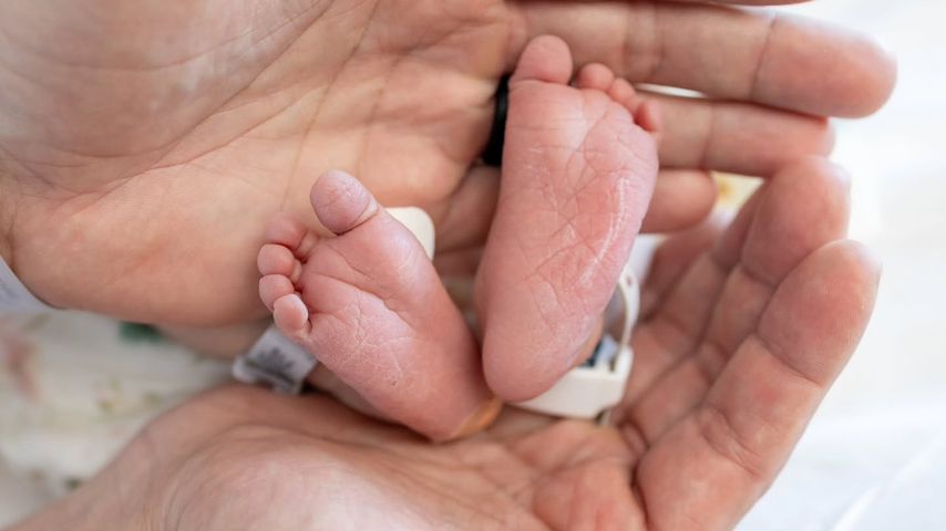 Amber Pike und Matthew Barnett mit den Füßchen ihres Babys, April 2025