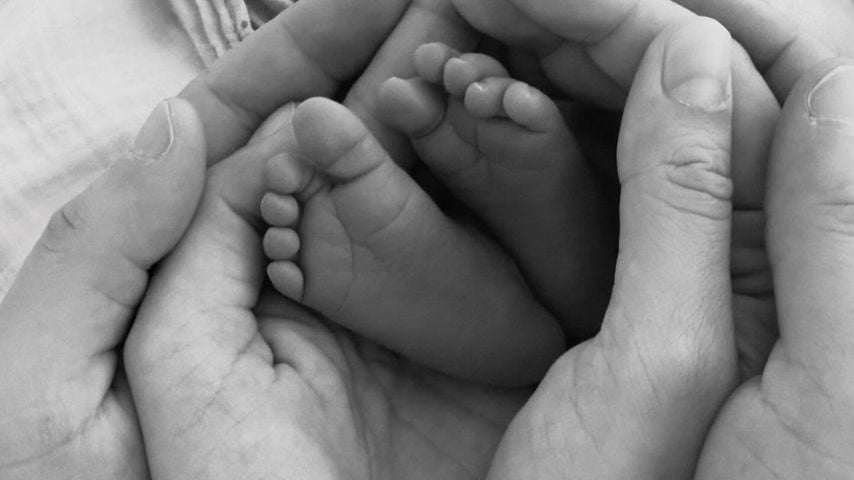 Die Hände von Mesut Özil und seiner Frau umschließen die Füße ihrer Tochter