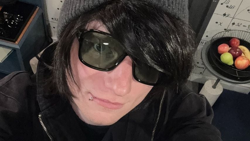 Ed Sheeran verkleidet mit schwarzer Perücke, Lippenpiercing und Sonnenbrille