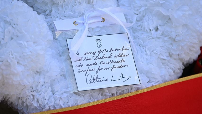 Eine handgeschriebene Karte mit der Inschrift von Kate, Prinzessin von Wales, und Unterschrift von Prinz William an einem weißen Kranz zum Anzac Day