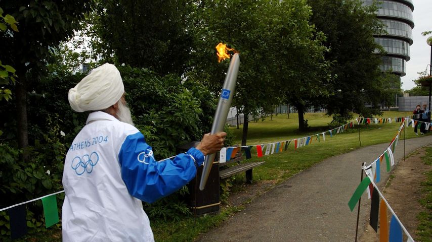 Fauja Singh trägt das olympische Feuer in Athen, 2004