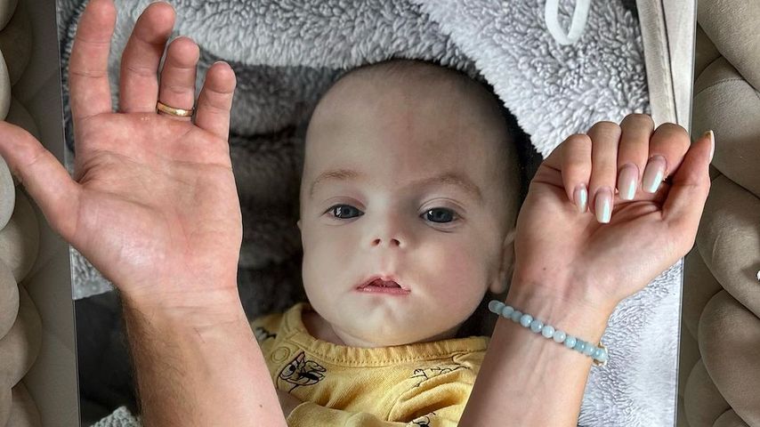 HealthyMandy und FitnessOskars Arme vor einem Bild ihres Babys Rio