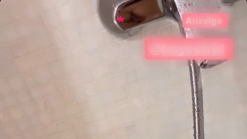 Iris Kleins Bein sowie ihre Brust in der Spiegelung der Armatur