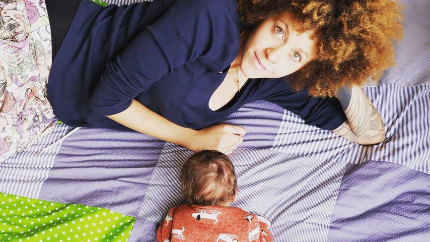 Joy Lee Juana Abiola-Müller auf einer Kuscheldecke mit Sohn Lovis