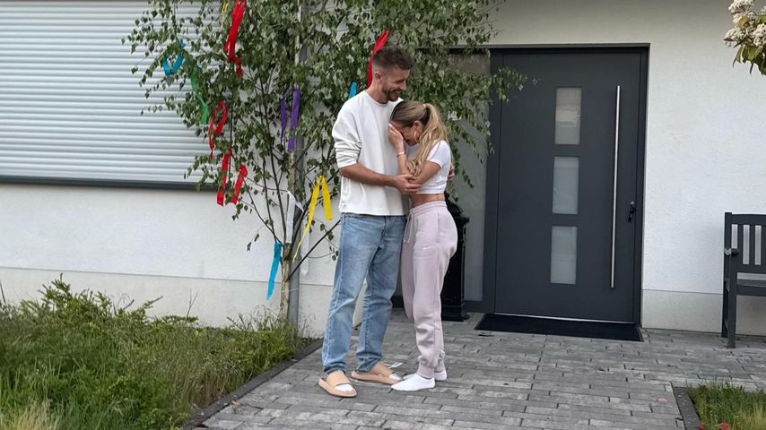 Julian Claßen und seine Freundin Palina vor einem Maibaum