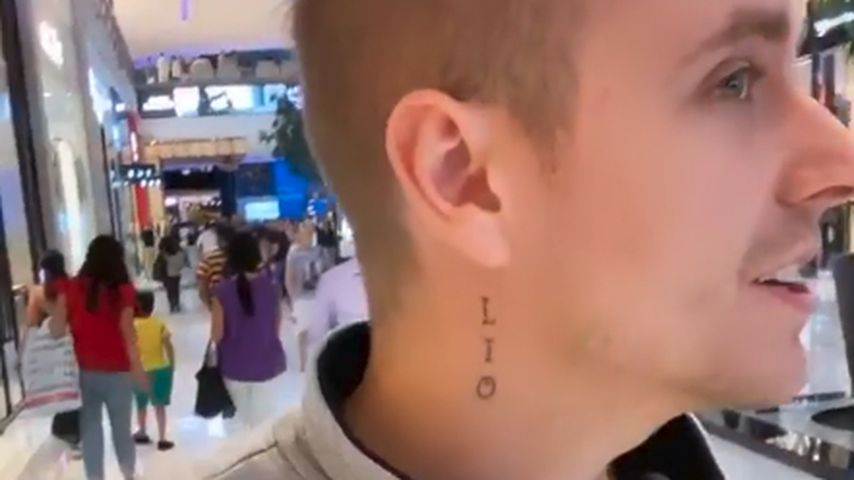 Julian Claßen mit aufgeklebtem Halstattoo