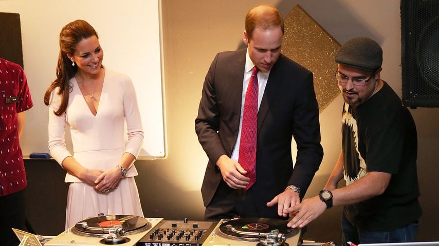 Kate, Herzogin von Cambridge, schaut zu, wie Prinz William im Northern Sound System in Elizabeth das Auflegen auf DJ-Decks erklärt bekommt