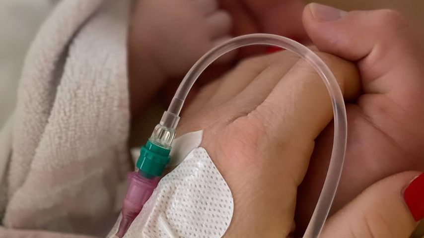 Katharina Wagener und Kevin Yanik halten Händchen mit ihrem Baby