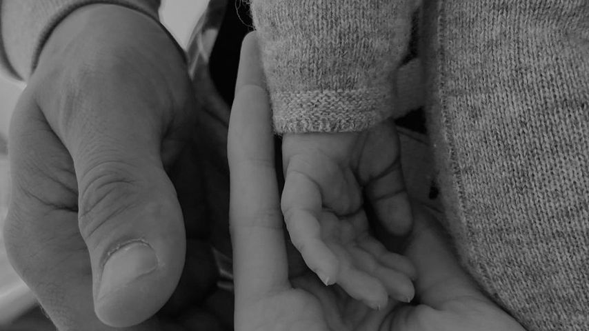 Kim Riekenberg und ihr Mann halten die Hand ihres Babys