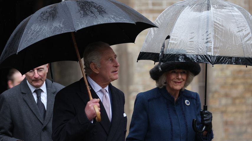 Ganz uneitel: Charles und Camilla tragen Regenschirme selbst