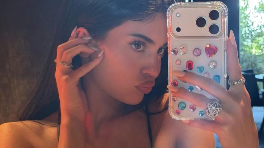 Kylie Jenner posiert mit einer funkelnden, mit Strasssteinen verzierten Handyhülle