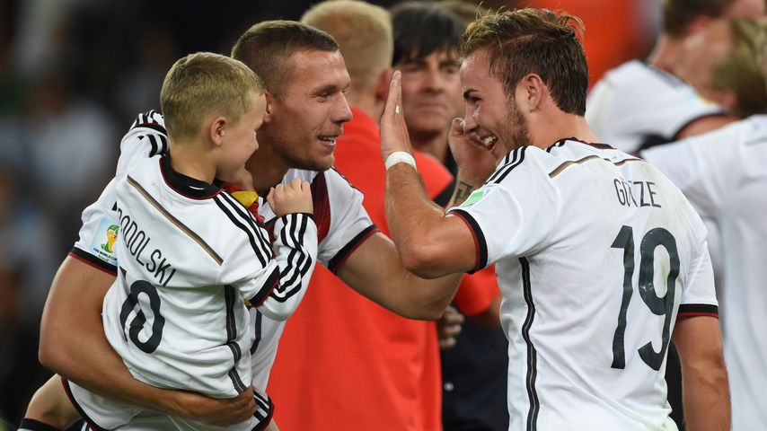 Lukas Podolski mit seinem Sohn auf dem Arm und Mario Götze, 2014