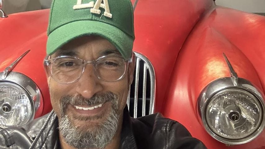 Mark Medlock posiert im April 2026 vor einem Oldtimer