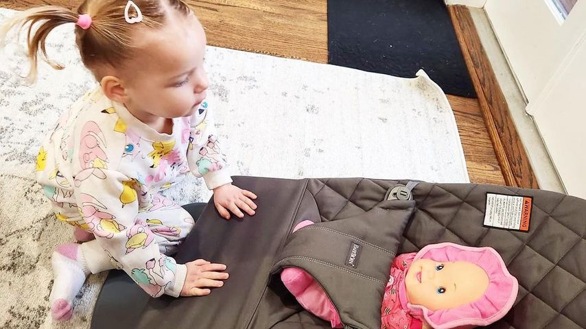 Meghan McCains Tochter Liberty mit Puppe in einer Babywippe