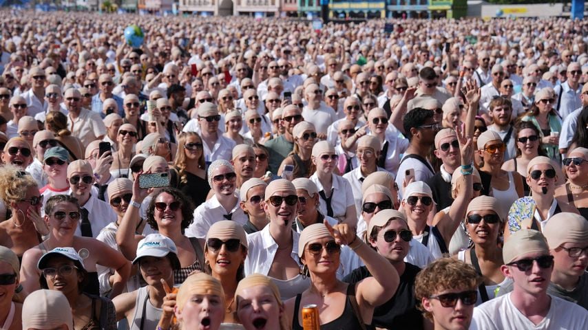 Fans mit Glatzenkappen vor Pitbulls Konzert im Hyde Park in London, 10. Juli 2026, mit Guinness-Weltrekordversuch
