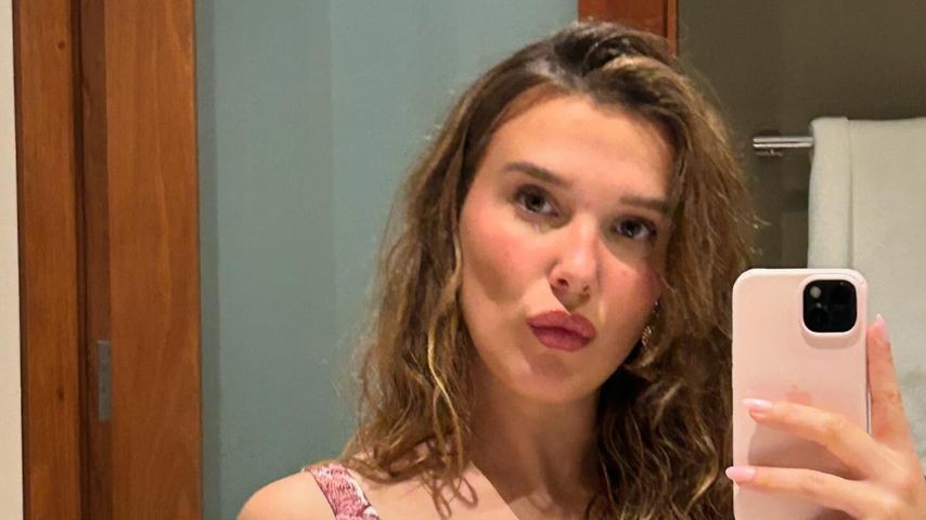 Millie Bobby Brown posiert in floralem Kleid und mit Louis-Vuitton-Tasche